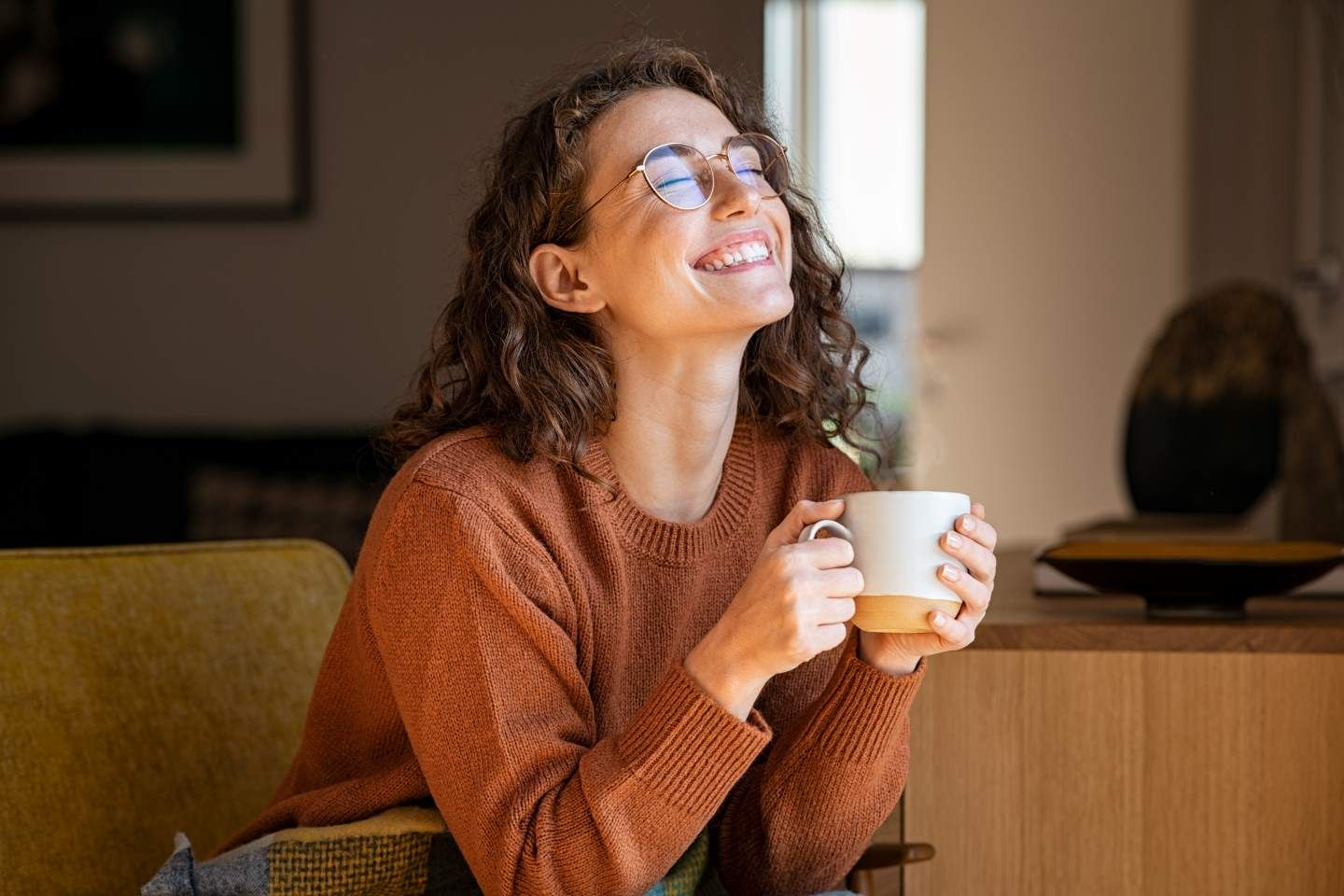 Lächelnde Frau mit Brille und Tasse.