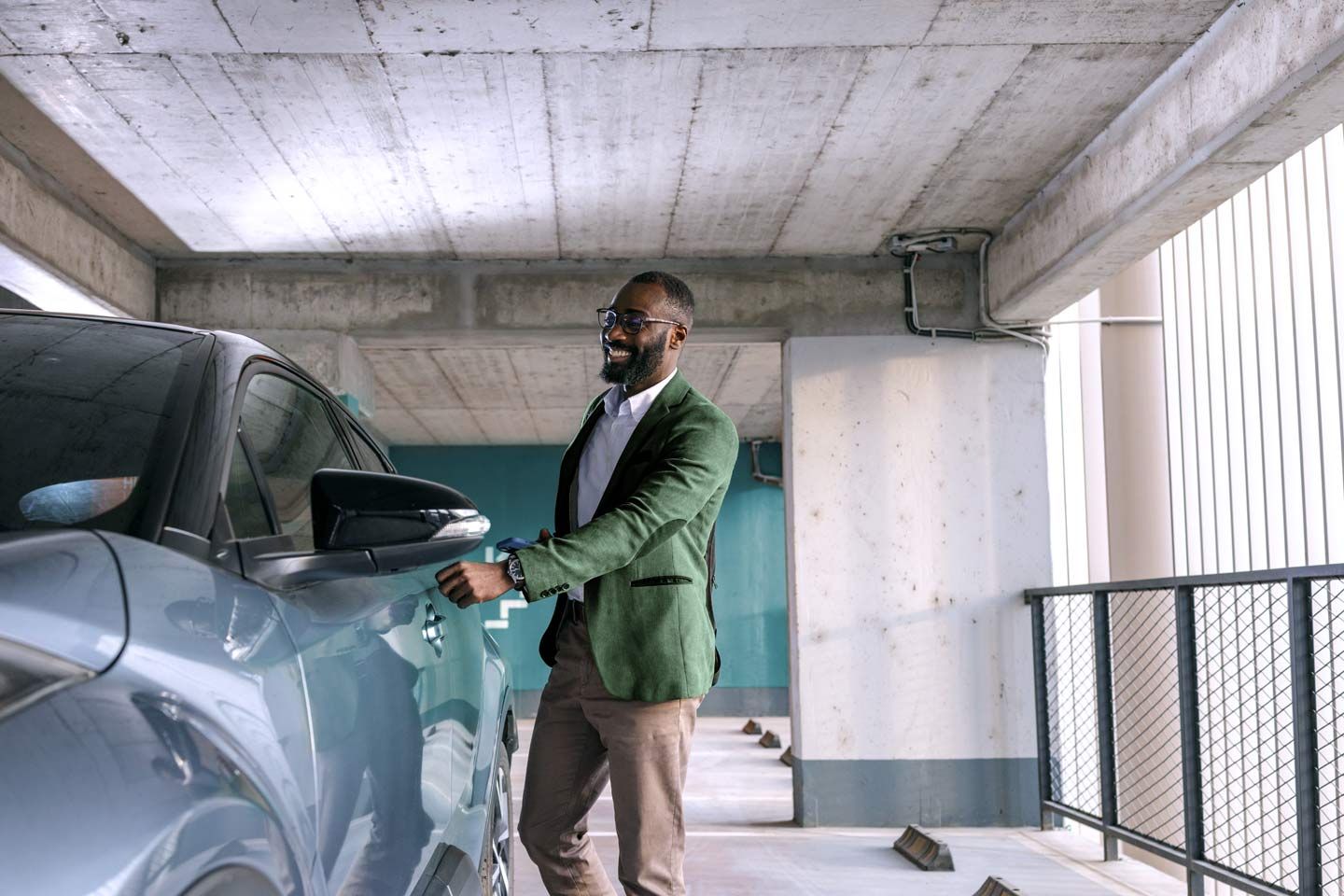 Ein Mann in einem Parkhaus steigt in seinen Wagen.