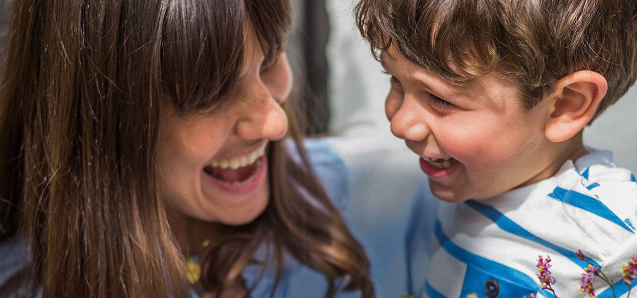 Eine Mutter und ihr Sohn lachen miteinander.