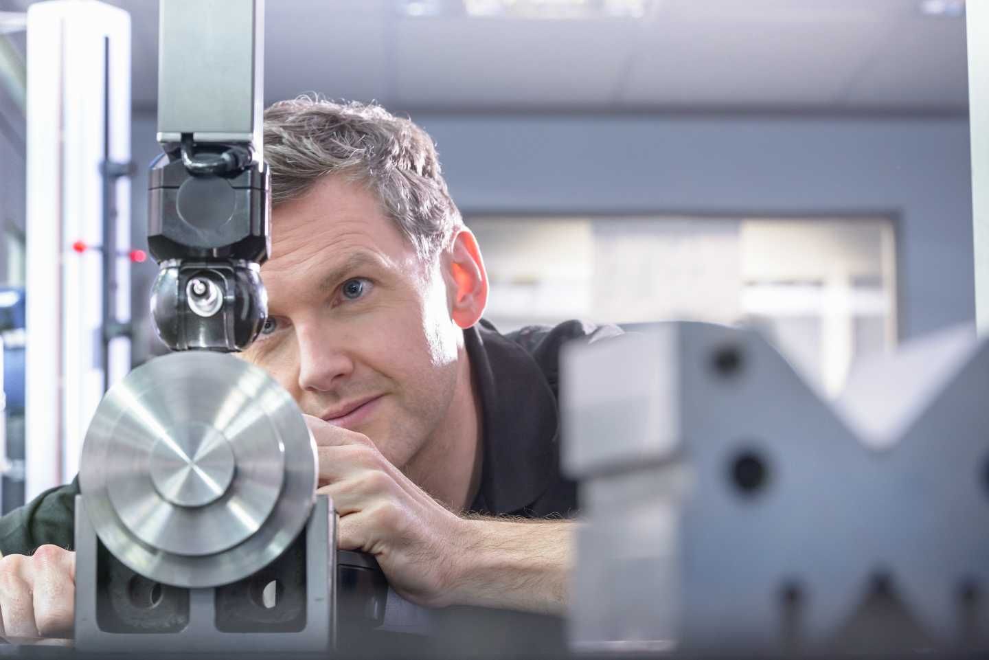 Ein Mann arbeitet in einer Werkstatt an einem technischen Gerät.