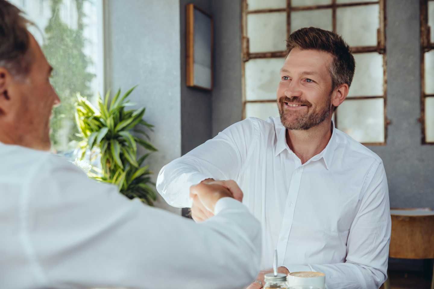 Zwei Männer schütteln sich die Hände.