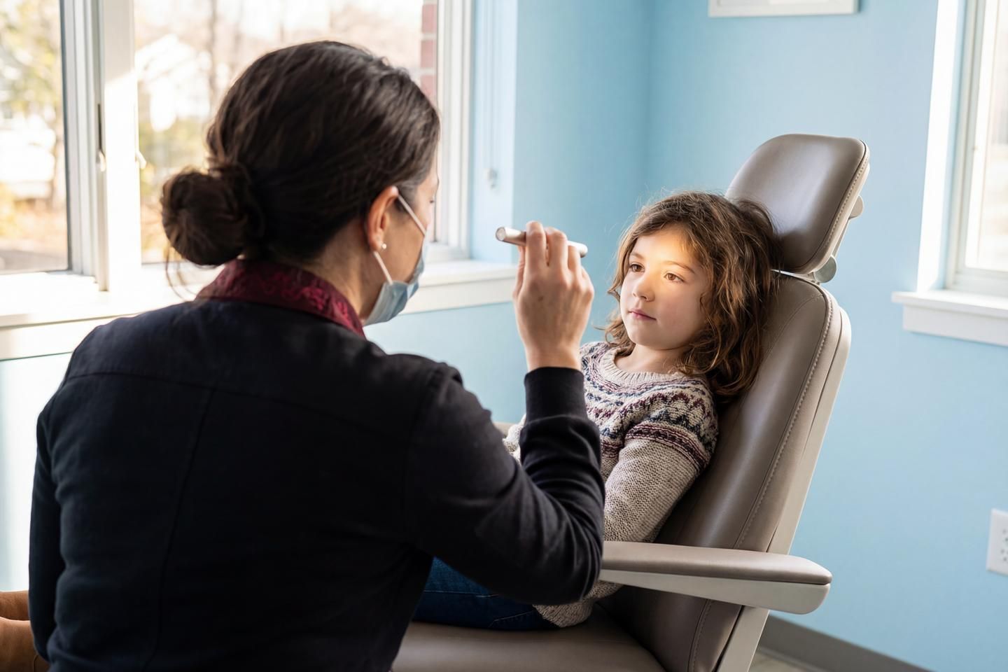 Junges Mädchen wird beim Augenarzt untersucht.