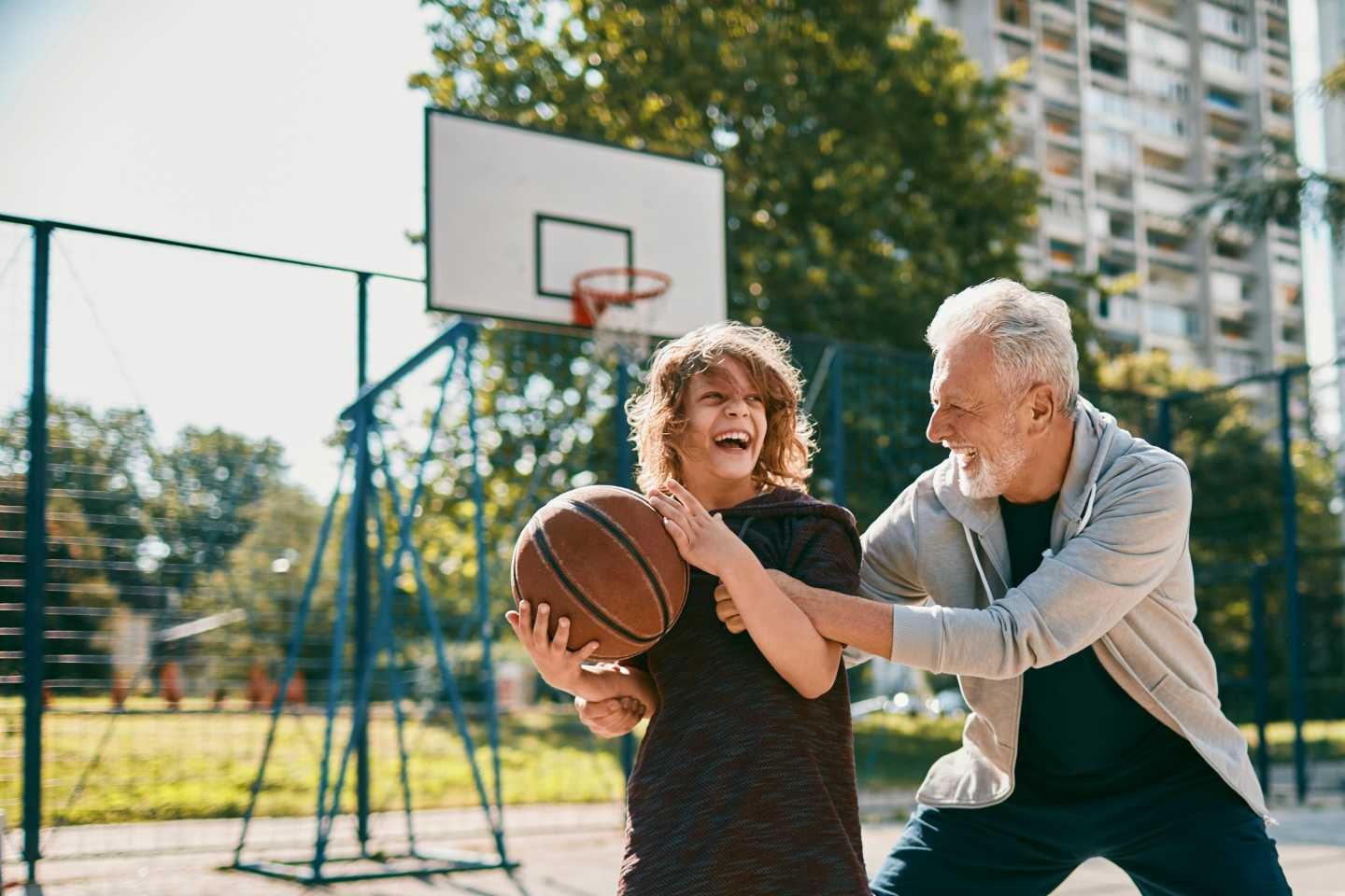 Großvater und Enkel haben Spaß beim Spiel mit einem Basketball.