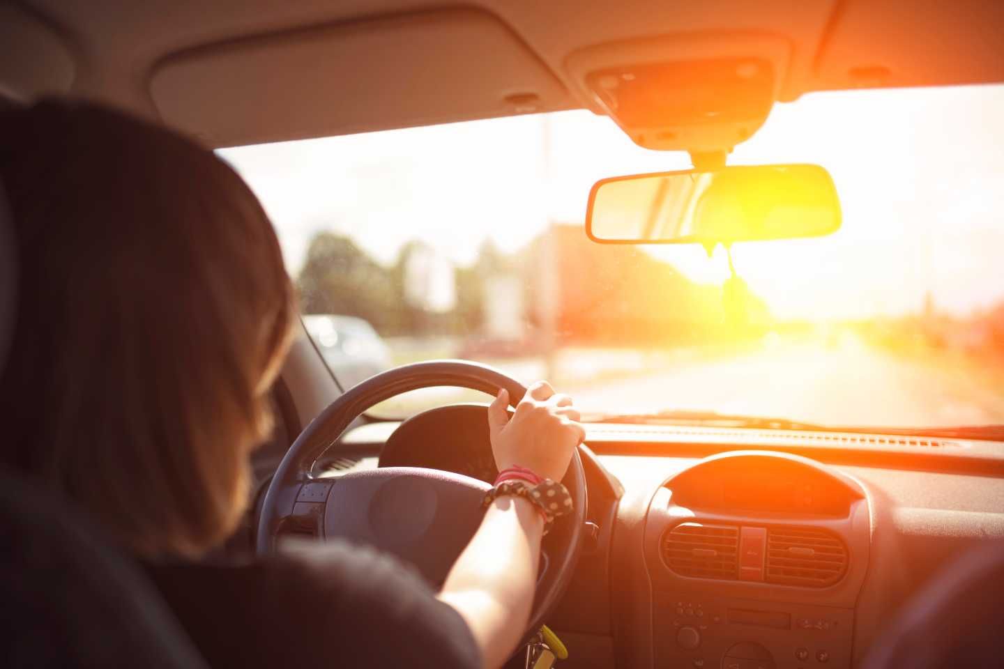 Eine Frau fährt dem Sonnenuntergang entgegen.