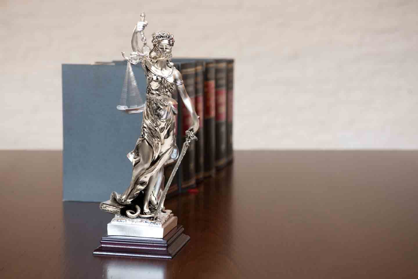 Die Justiza steht auf dem Schreibtisch mit Büchern.