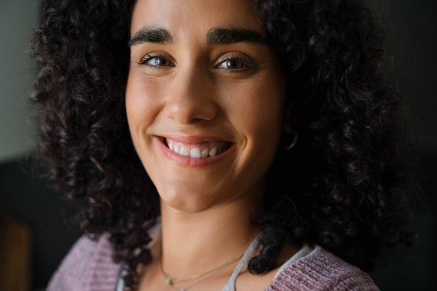 Lächelnde Frau mit lockigen Haaren.