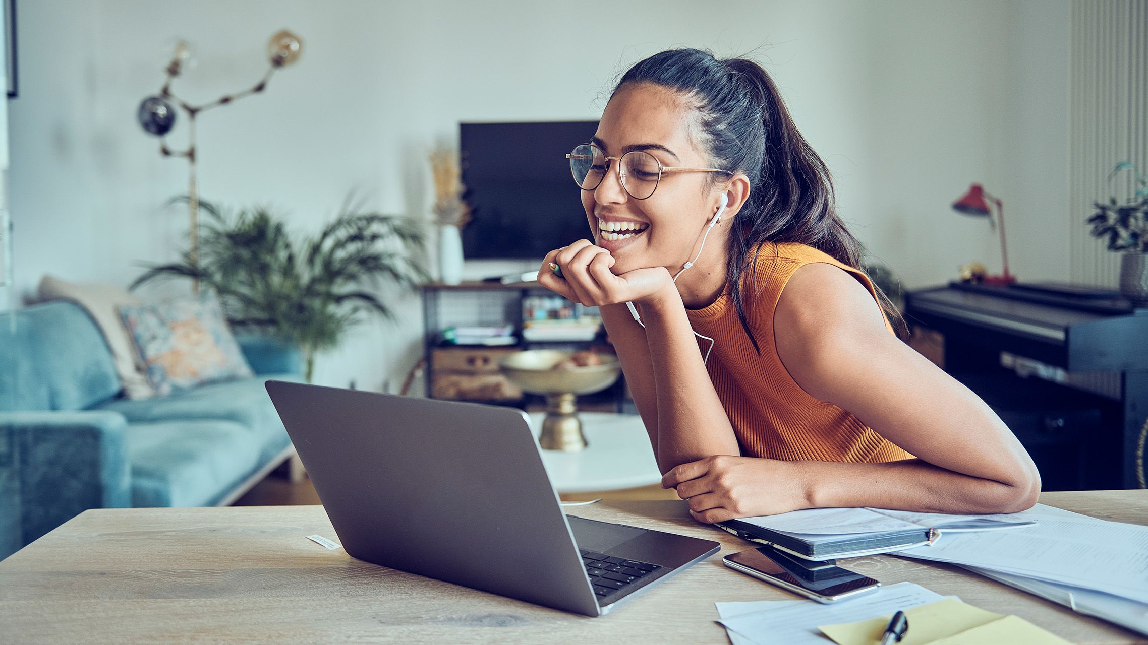 Person mit Brille arbeitet an einem Laptop im Homeoffice und blickt auf den Bildschirm.
