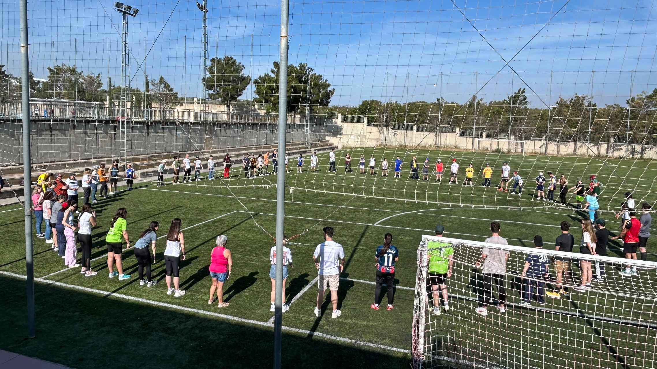 Personen stehen in einem Kreis in einem Stadion