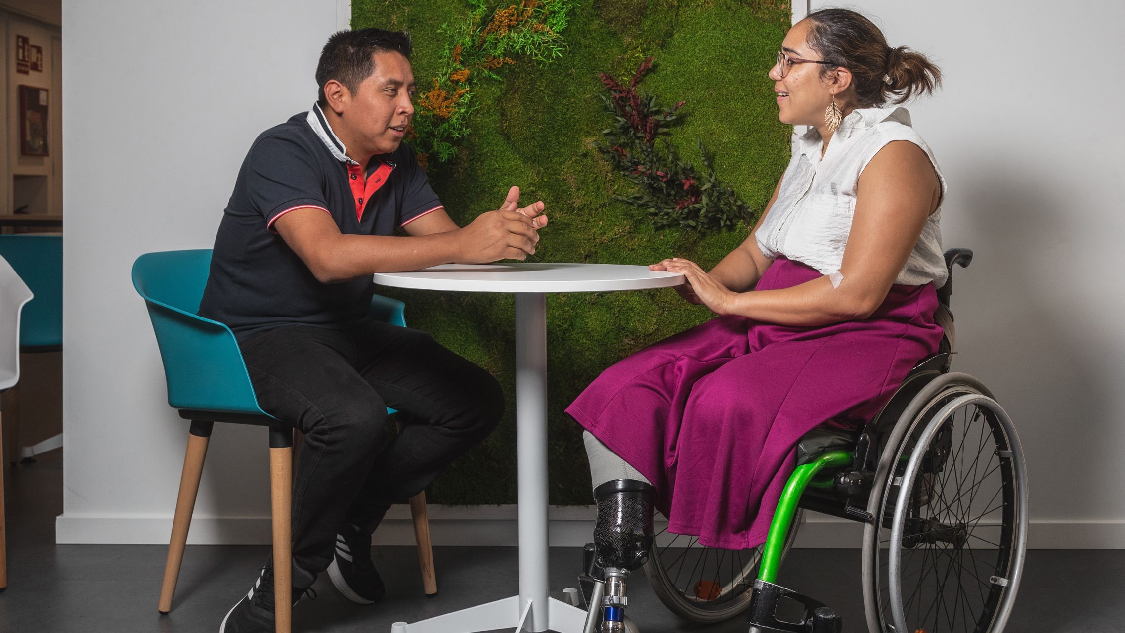 Zwei Personen sitzen am Tisch und unterhalten sich