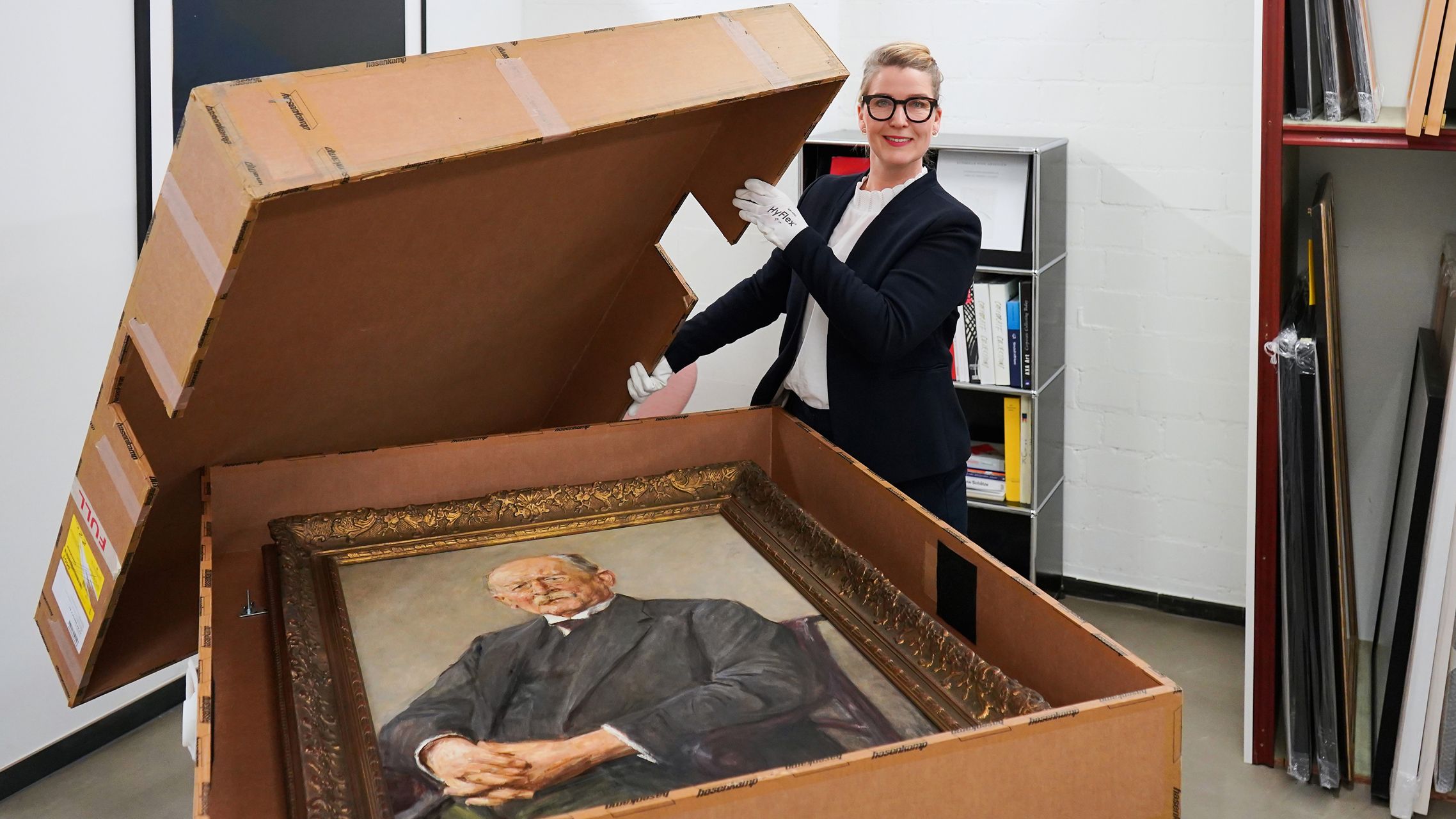 ERGO Kuratorin Tine Bay Lührssen mit dem Porträt von Otto Gerstenberg für den Versand zur Ausstellung.