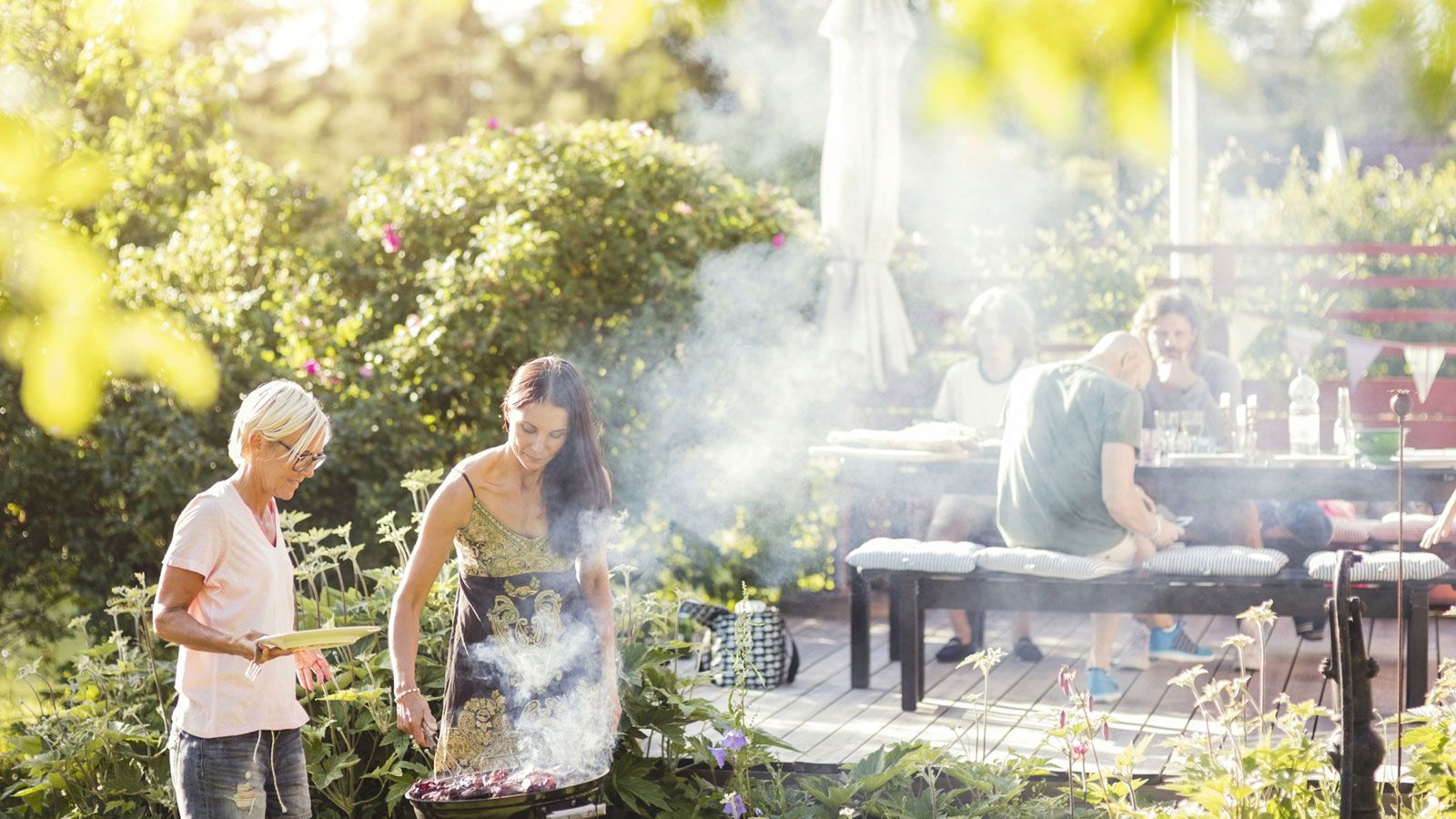 Eine Gruppe von Menschen grillt gemeinsam im Freien.