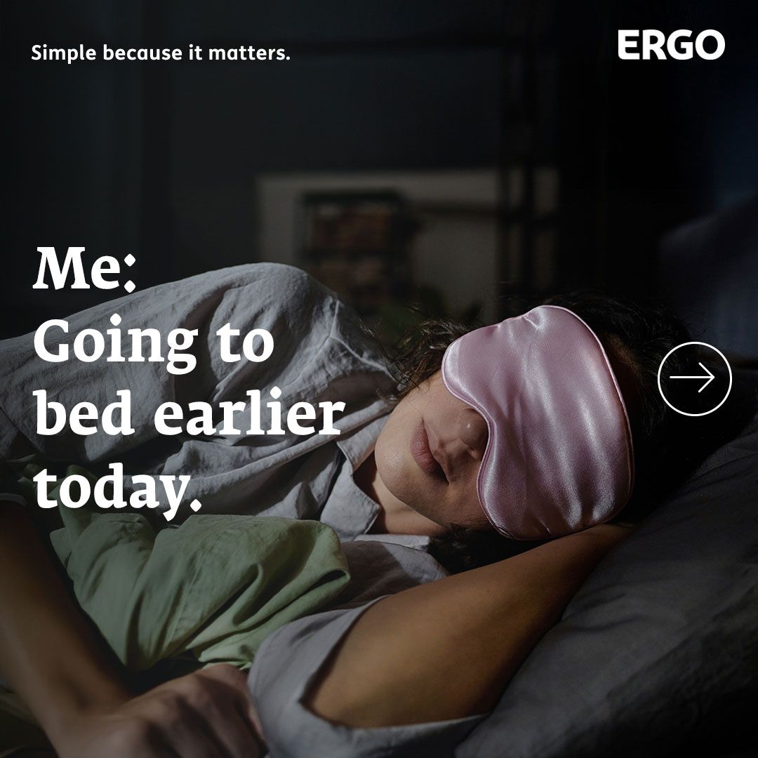 A woman is lying in bed wearing a pink sleep mask.