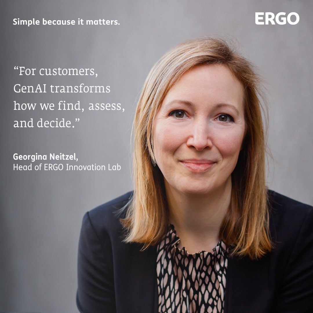 Blonde woman wearing a black blazer in front of a grey background.