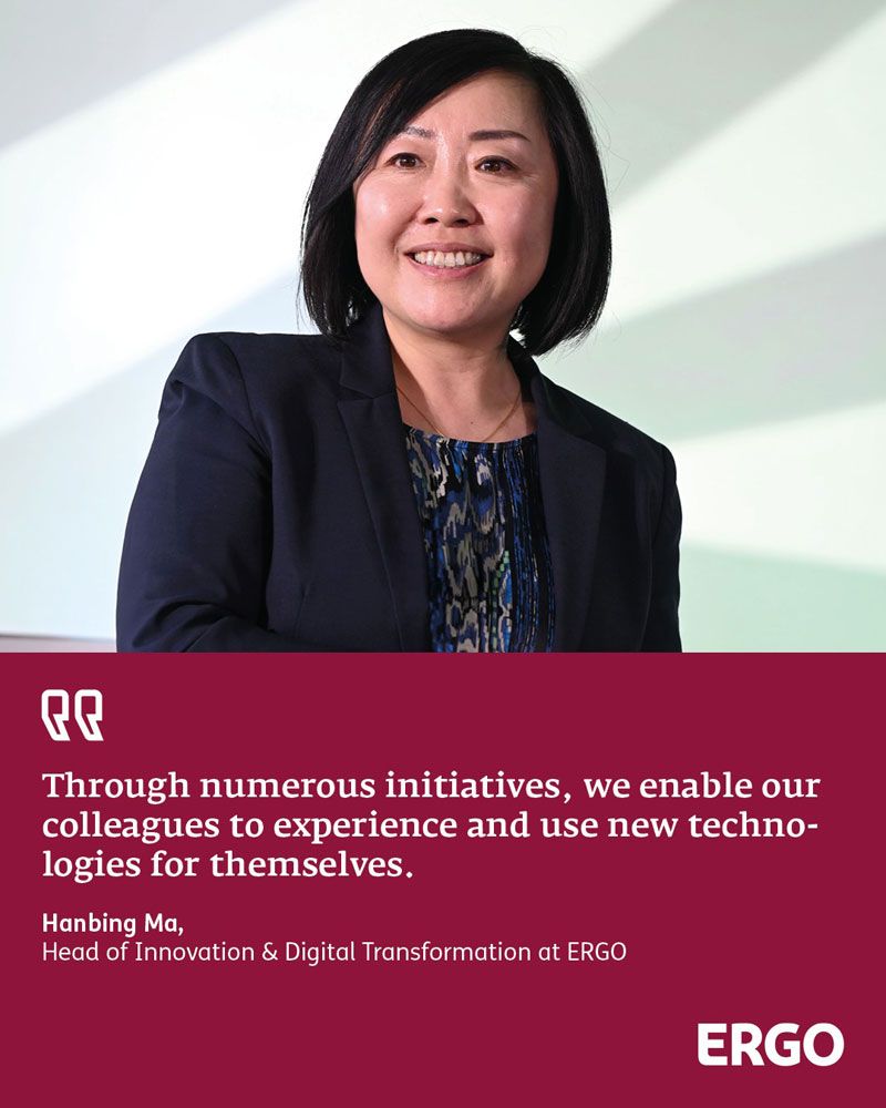 Ms Ma is wearing a black blazer and a black blouse and is smiling at the camera. 