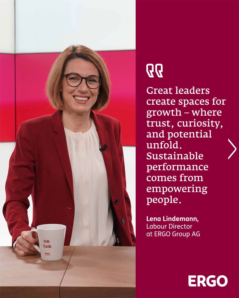 Ms Lindemann is wearing a red blazer with a white blouse and is smiling at the camera.