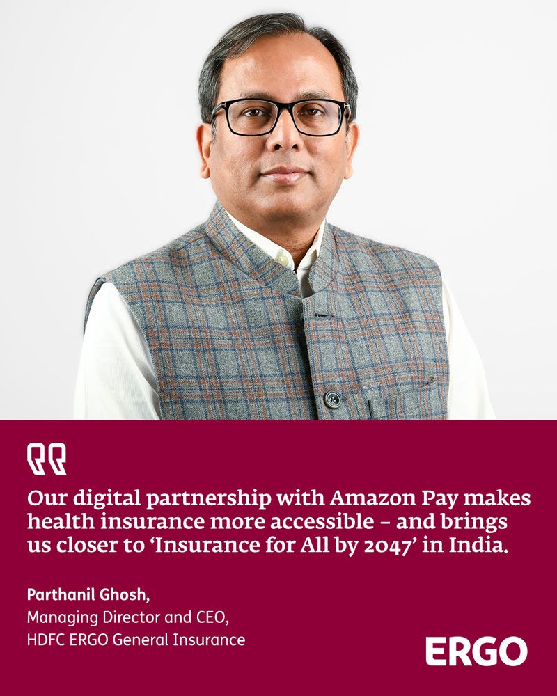Portrait of an Indian man with short hair and glasses, wearing a white shirt and a grey checked waistcoat.