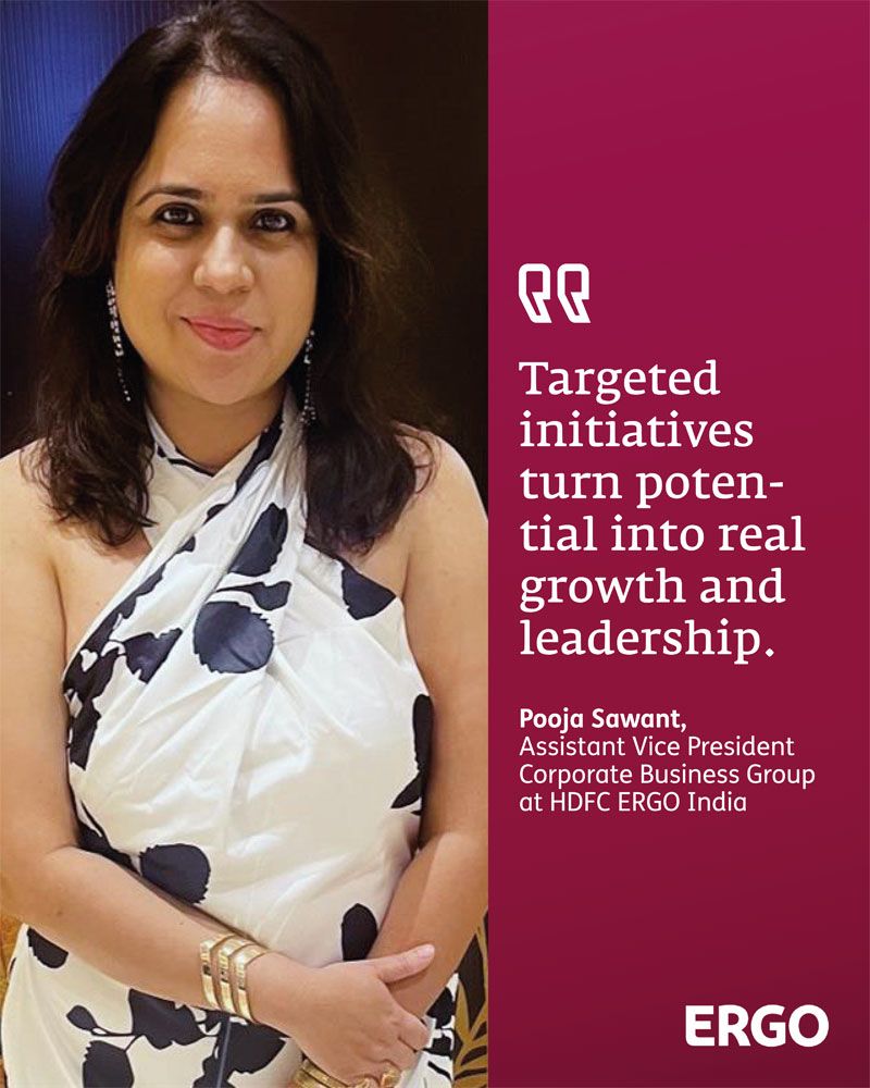 A woman in a black and white dress smiles at the camera.