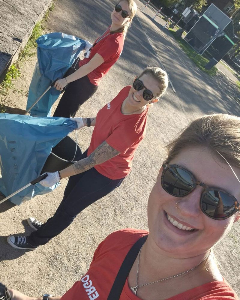 Mitarbeitende reinigen das Außengelände zum World Cleanup Day.