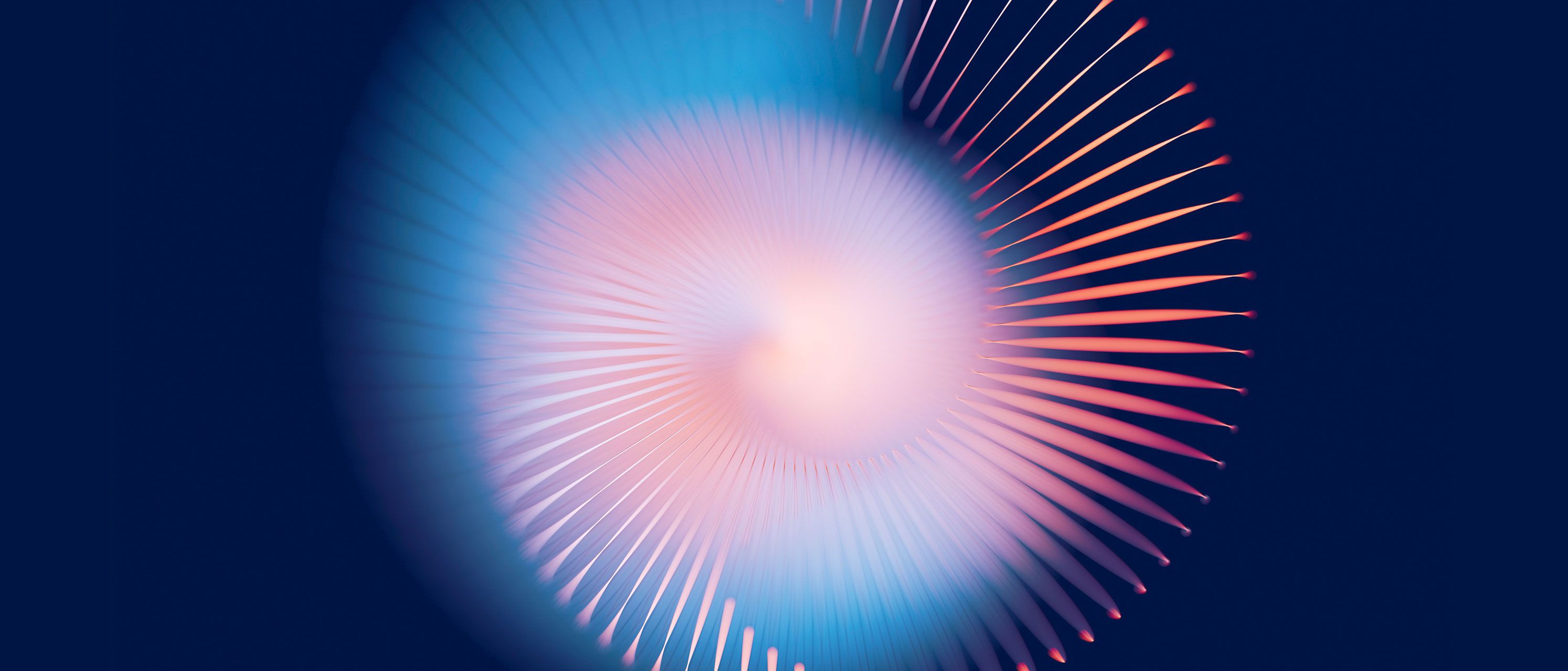 Kreisförmiges Lichtspiel aus hellblau, rosa und orange auf einem dunkelblauen Hintergrund.