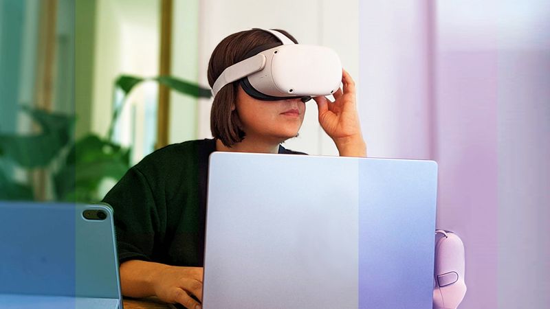 Frau mit VR Brille auf, vor einem Laptop