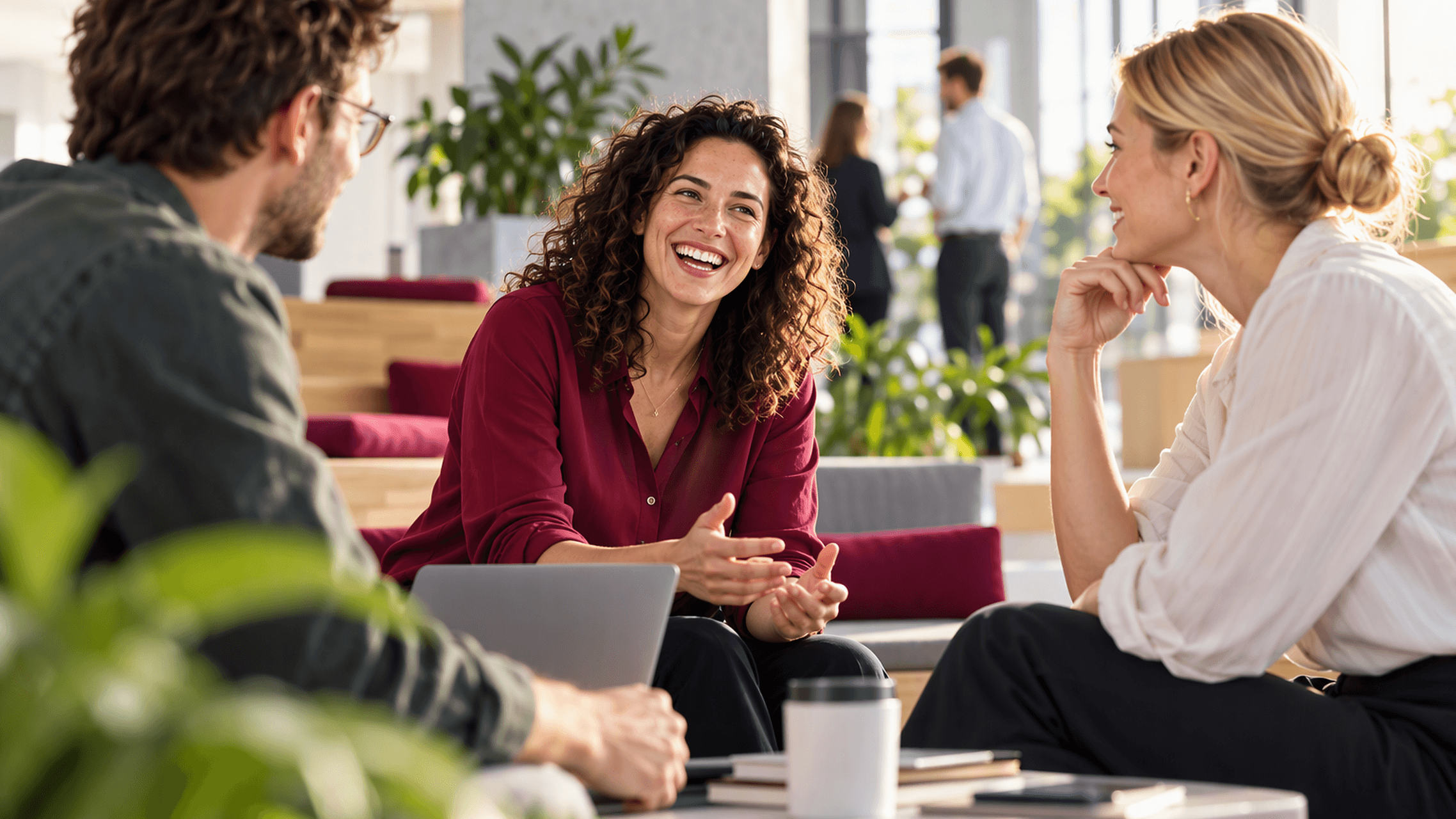 Drei Personen tauschen sich in einem modernen Büro über gemeinsame Themen aus. (Bild KI-unterstützt generiert)