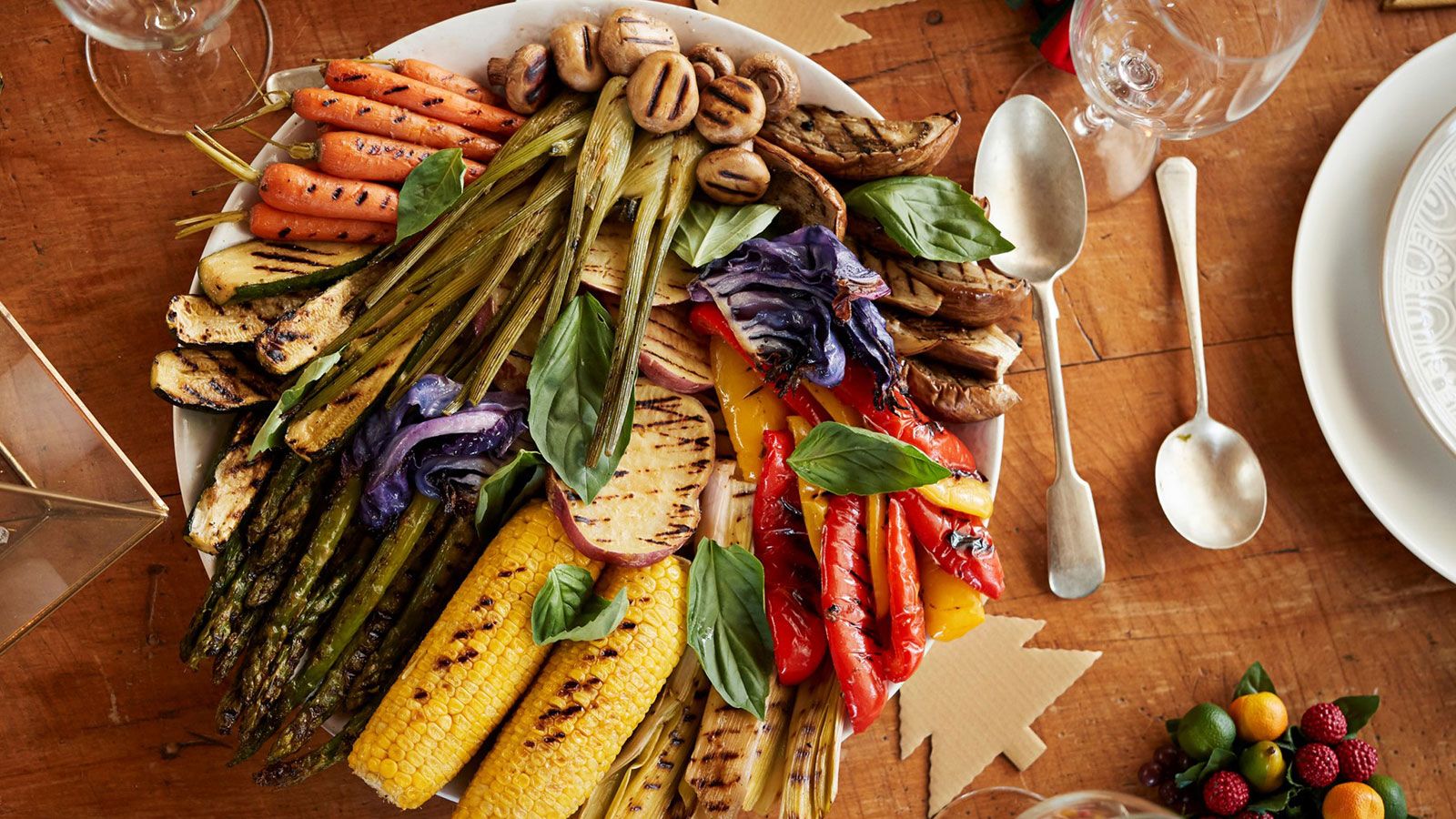 A colorful platter of vegetables on a table, cutlery next to it.