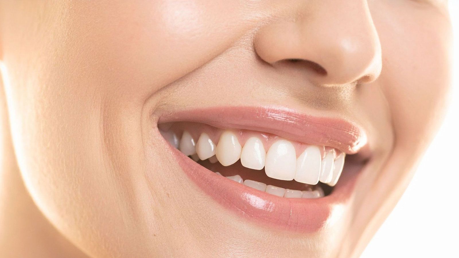 A woman shows off her smile with white teeth.