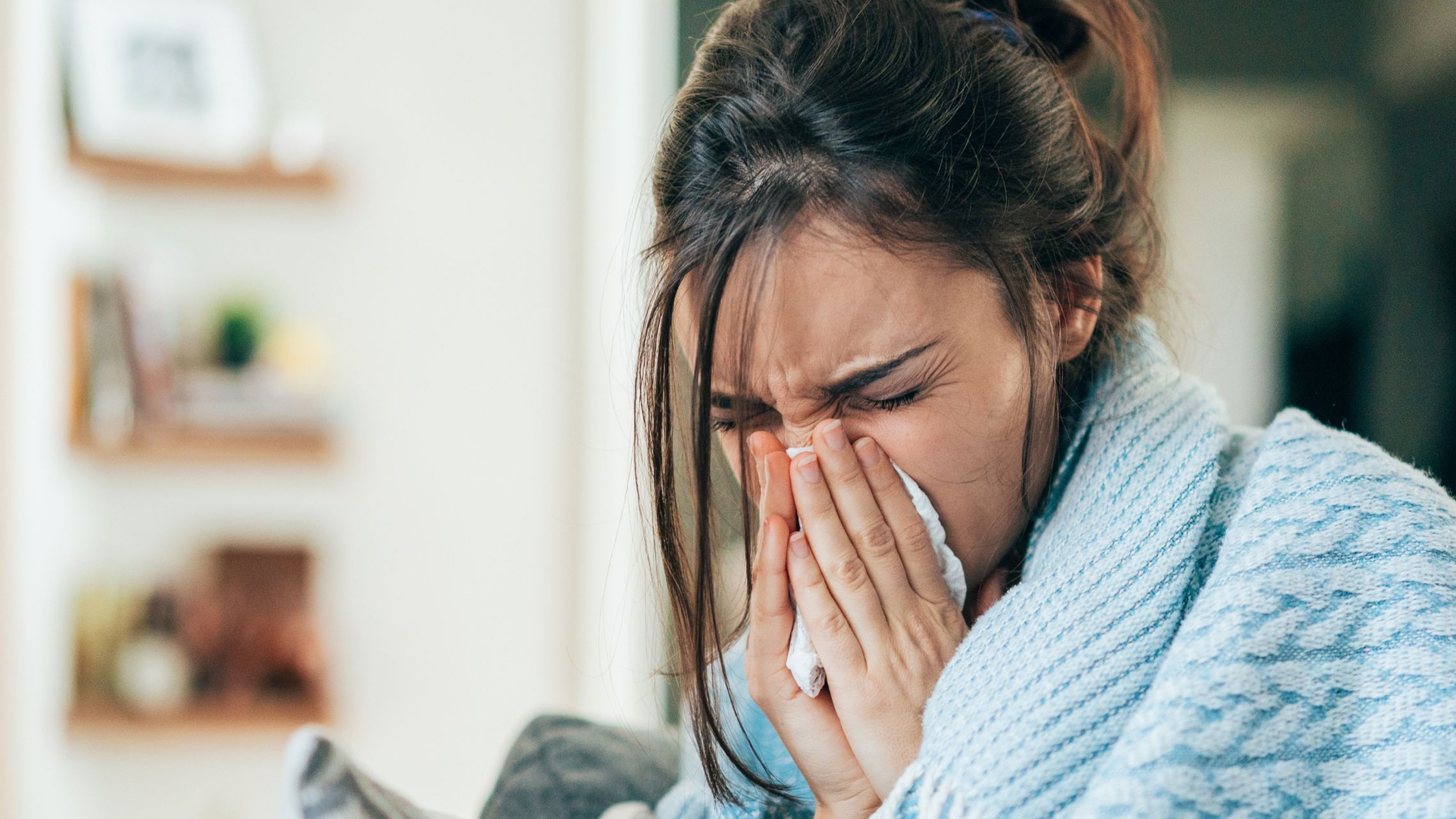 Frau putzt sich die Nase