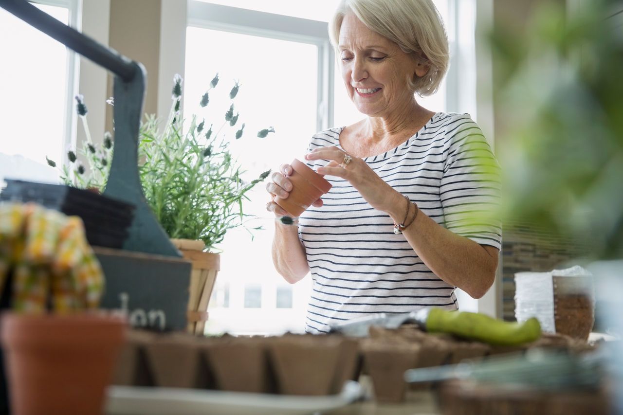 Frau die Blumen im Haus macht