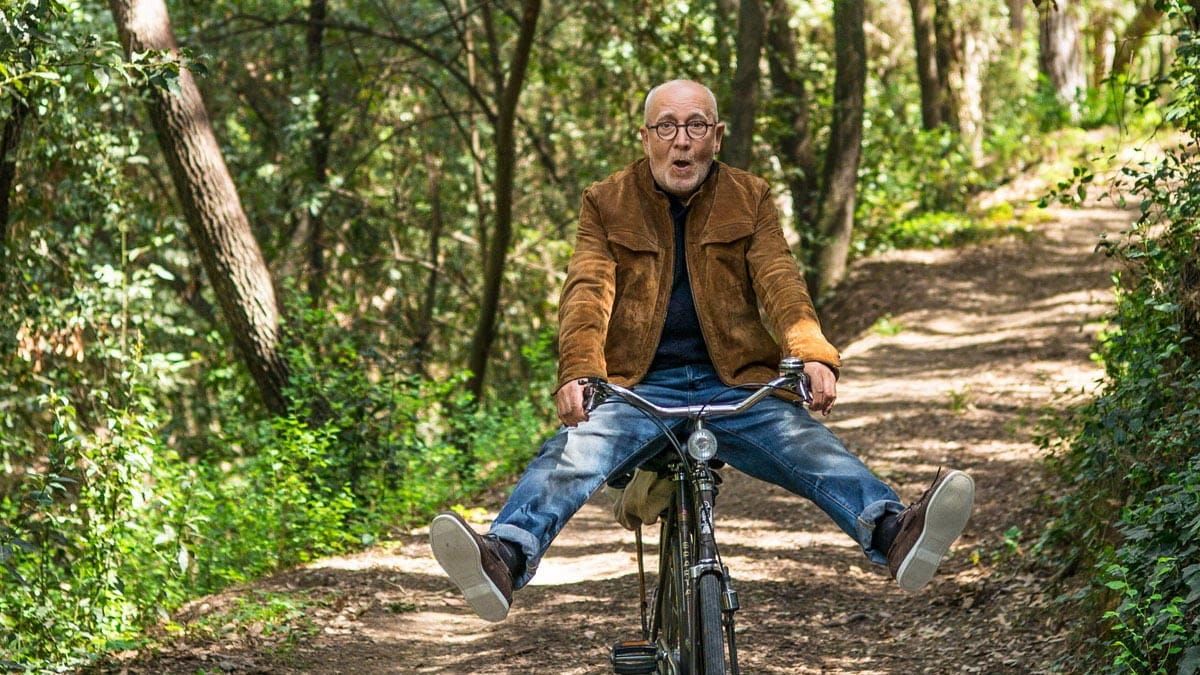 Mann fährt auf dem Fahrrad durch den Wald und fährt mit den Beinen in der Luft